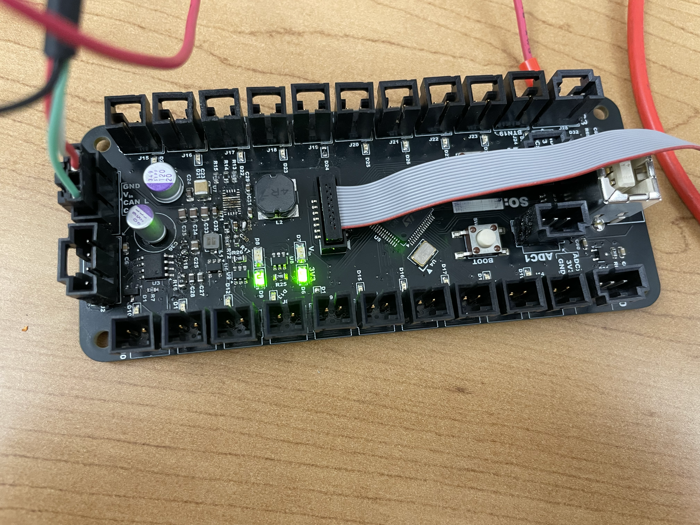 The fully assembled controller board with power connected and software successfully flashed, showing all status LEDs lit up and ready for operation.